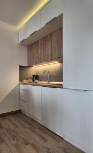 a kitchen with white cabinets and a sink at Kopaonik Lux Resident Hill Apartman A39 in Kopaonik