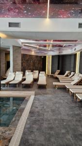 a room with chairs and a pool in a building at Kopaonik Lux Resident Hill Apartman A39 in Kopaonik +11 photos