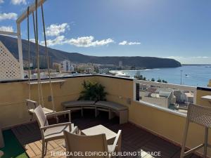 a balcony with chairs and a table and a view of the water at Apartamentos Ohana - Edificio Tonillo in Los Cristianos