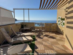 a balcony with chairs and tables and a view of the ocean at Apartamentos Ohana - Edificio Tonillo in Los Cristianos