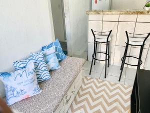 a counter with some blue and white pillows on it at Sua Kitnet a menos de 5min da Praia in Santa Cruz Cabrália