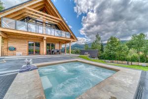 a house with a pool in front of it at Pine Tree Chalet in Zawoja