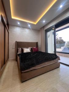 a bedroom with a large bed with a large window at Villa familiale avec piscine in Agadir
