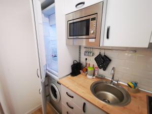 a small kitchen with a sink and a microwave at ALDIRA Studio Arena Nationala in Bucharest