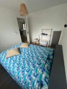 a bedroom with a bed with a blue comforter at T2 au calme, la mer à proximité in Villeneuve-lès-Maguelonne