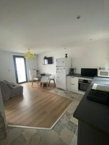 a kitchen and living room with a table and a refrigerator at T2 au calme, la mer à proximité in Villeneuve-lès-Maguelonne
