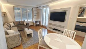 un salon avec un canapé, une table et une télévision dans l'établissement Arena Lux apartment, à Belgrade