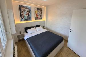 - une chambre avec un lit orné de deux peintures murales dans l'établissement Arena Lux apartment, à Belgrade