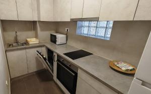 une petite cuisine avec un évier et un micro-ondes dans l'établissement Arena Lux apartment, à Belgrade