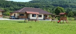 a playground in front of a house with a house at Apartament Betula in Sovata