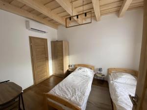 a room with two beds and a chandelier at Nagy Bujdosó Vendégház in Tardona