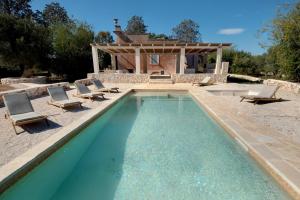 une piscine avec des chaises et une maison dans l'établissement Antique Villa, Casa Rosa - 3 bed, 2 bath with pool, à Ceglie Messapica