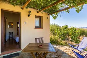 a wooden table and chairs on the patio of a house at Anastè in Buseto Palizzolo
