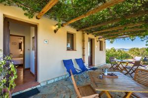a patio with blue chairs and a table on a house at Anastè in Buseto Palizzolo +31 photos