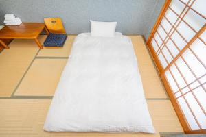 a room with a bed and a desk and windows at Fujiminoyado - Vacation STAY 62041v in Gotemba