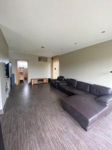 a living room with a leather couch and a tv at Mārtiņmāja in Saraiķi +12 photos