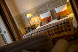 a bedroom with a large bed with a large mirror at Villa Augeval Hôtel de charme & Spa in Deauville