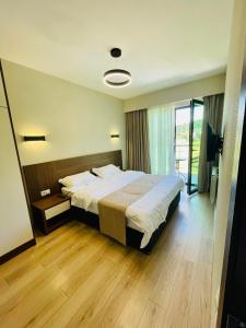 a bedroom with a large bed and a large window at Bakuriani, crystal residence 405 room in Bakuriani +19 photos