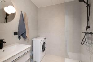 a bathroom with a washing machine and a sink at Revalia Lastekodu-Odra Bus Station Airport Apartments in Tallinn +53 photos