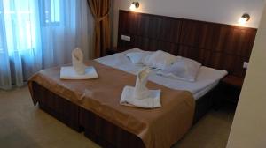 a hotel room with a bed with towels on it at Cabana Claris in Văliug