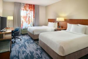 a hotel room with two beds and a desk and a television at Fairfield Inn & Suites by Marriott Jackson in Jackson +10 photos