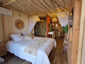 a bedroom with a large bed and a kitchen at Barcazen in Le Barcarès