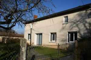 a white house with a fence in front of it at Location des longères in Brux