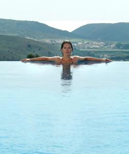 
a woman in a bikini standing in the water at Quinta da Floresta – Santo António Villas, Golf & Spa in Budens
