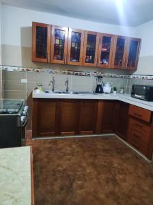 a kitchen with wooden cabinets and a sink at no disponibl in Trujillo +5 photos