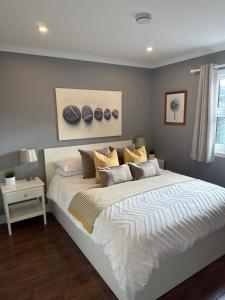 una camera da letto con un grande letto bianco con cuscini di Holly Lodge - 2 x Kingsize bedrooms with private entrance and free parking-new shower room a Oban