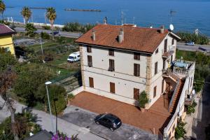 een wit huis met een rood dak naast de oceaan bij Acquamarina in Grottammare