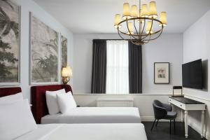 a hotel room with a bed and a desk and a chandelier at Adahan DeCamondo Pera, Autograph Collection in Istanbul +81 photos