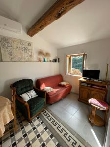 a living room with a couch and a chair at appartement chez l'artiste in Minerve +22 photos