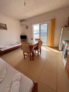 a kitchen and dining room with a table and a window at Majki Beach Apartments in Sarandë