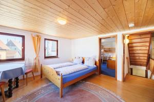 a bed in a room with a wooden ceiling at Haugstetter Schwarzwaldhaus in Neubulach
