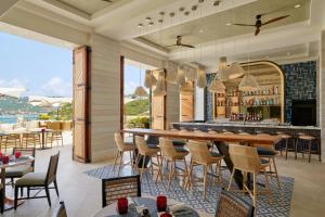 un ristorante con bar, tavoli e sedie di Buoy Haus Beach Resort St Thomas Autograph Collection a Nazareth