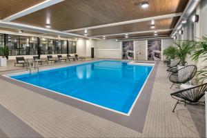 a large swimming pool with blue water in a building at The Insignia Hotel, Sarnia, a Tribute Portfolio Hotel in Sarnia