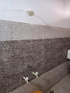 a shower with a shower head on a brick wall at Agrima palace in Rewa