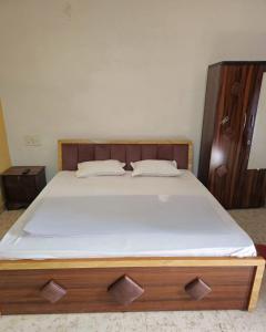 a bedroom with a bed with a wooden headboard at Agrima palace in Rewa