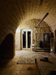 Zimmer mit Ziegelwand, Tür und Sofa in der Unterkunft Il Magazzeno della Prozia in Corato + 16 Fotos