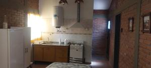 a kitchen with a stove and a refrigerator at Cabañas Don Pocho in Villa Cura Brochero