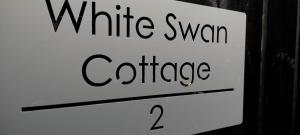 un segno bianco con le parole caffè cigno bianco di White Swan Cottage 2 a Hunmanby