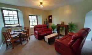 a living room with red furniture and a table at Cosy seaside flat - 40 min to Edinburgh in Burntisland