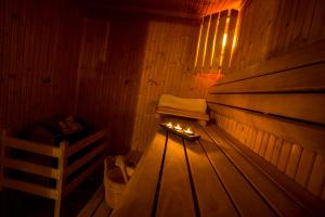 a wooden sauna with a bench and a fire in it at Villa Augeval Hôtel de charme & Spa in Deauville