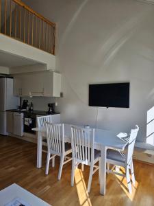 a dining room with a white table and chairs at Mountain view 2 in Håra
