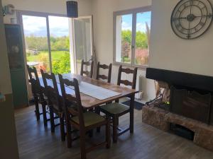 a dining room with a table and chairs and a fireplace at Spacieuse Maison Familiale avec Jardin 8 personnes Trégastel in Trégastel