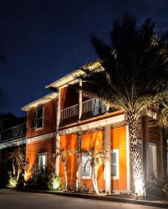 a building with a palm tree in front of it at Sea la vie in Grand Isle