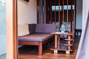 a bench sitting on a porch with a table at Secret Garden Villa in Kendwa