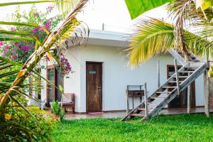 a white house with a staircase in front of it at Secret Garden Villa in Kendwa