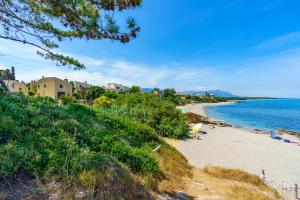une plage avec des gens sur le sable et l'eau dans l'établissement La Caletta Corsa Apartments - 2 Camere, Terrazza Privata a 100m dal Mare, WiFi Fibra, à Linguizzetta